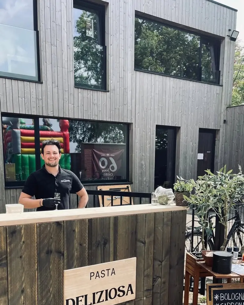 Lachende kok achter de stijgerhouten bar in Beernem