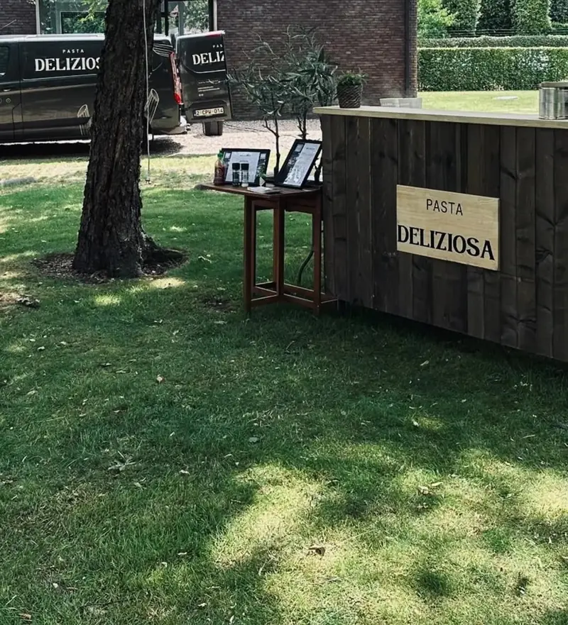 De stijgerhouten bar onder de bomen in een tuin in Lochristi