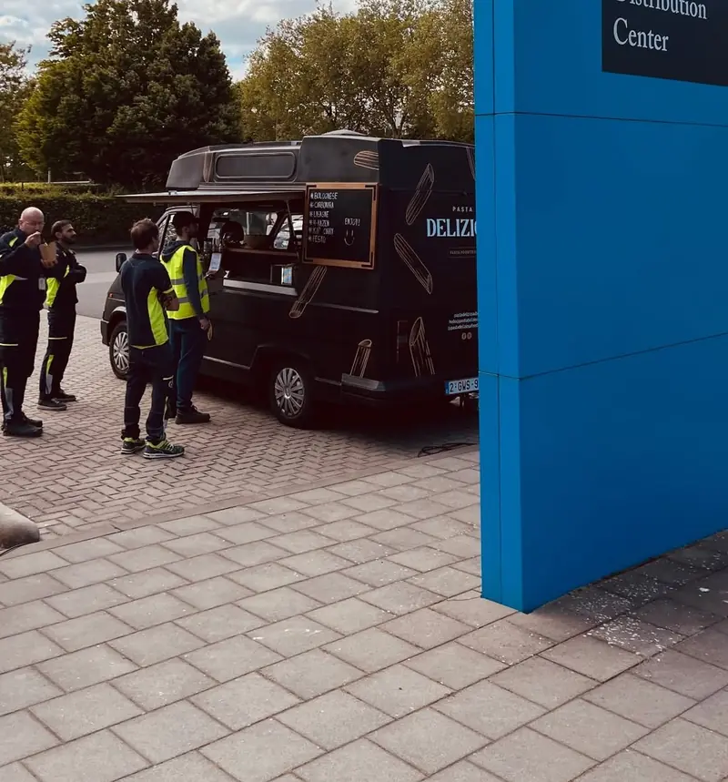 De oldtimer bij het distributiecentrum van Donaldson in Brugge, medewerkers in fluohesjes schuiven aan