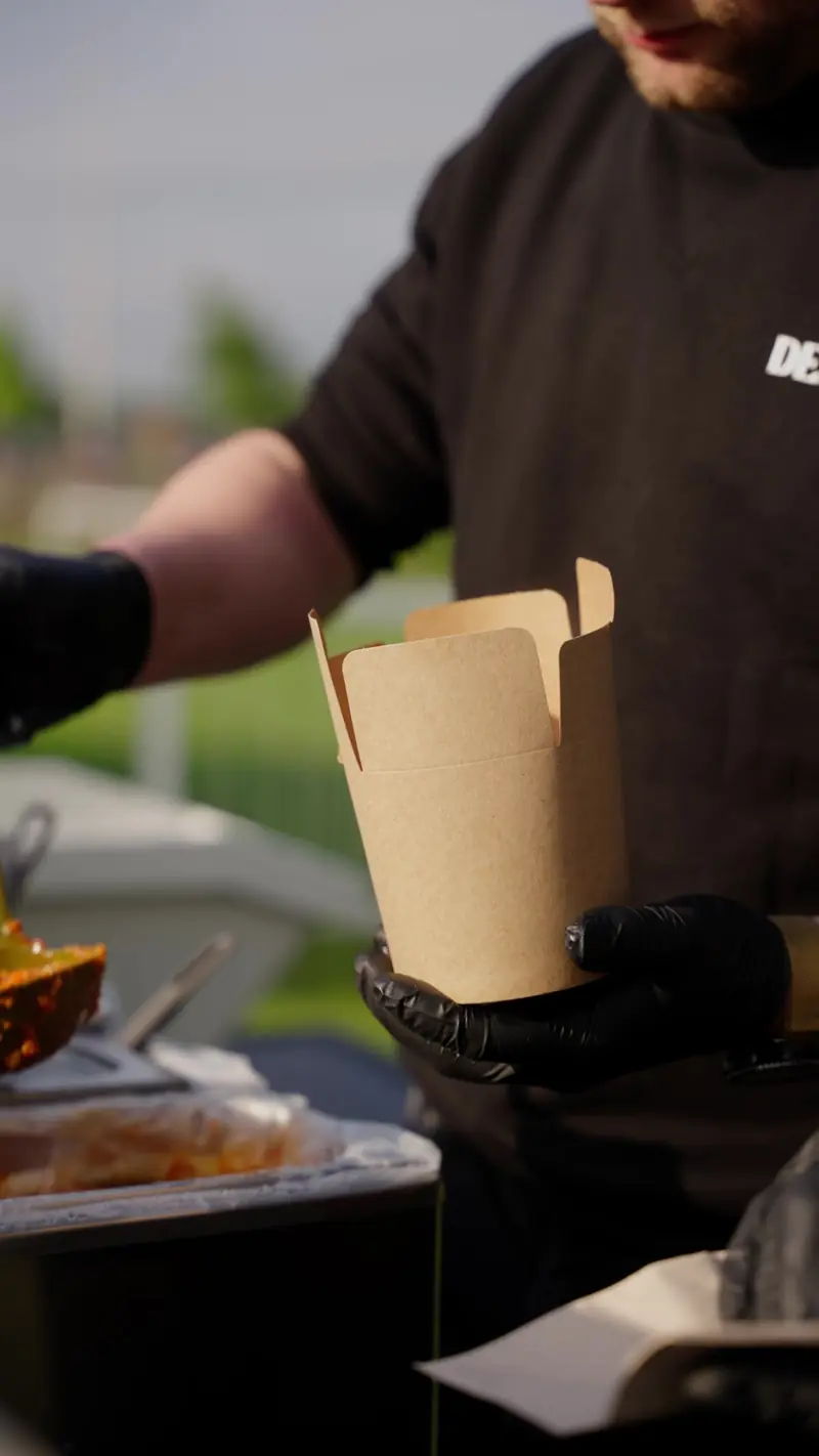 Kartonnen pastabox in de handen van de kok