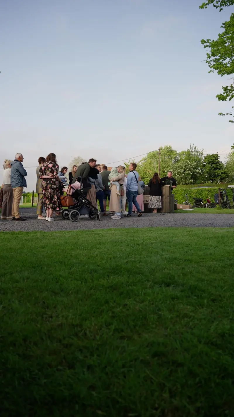 Gasten eten hun pasta op het gazon tijdens een feest