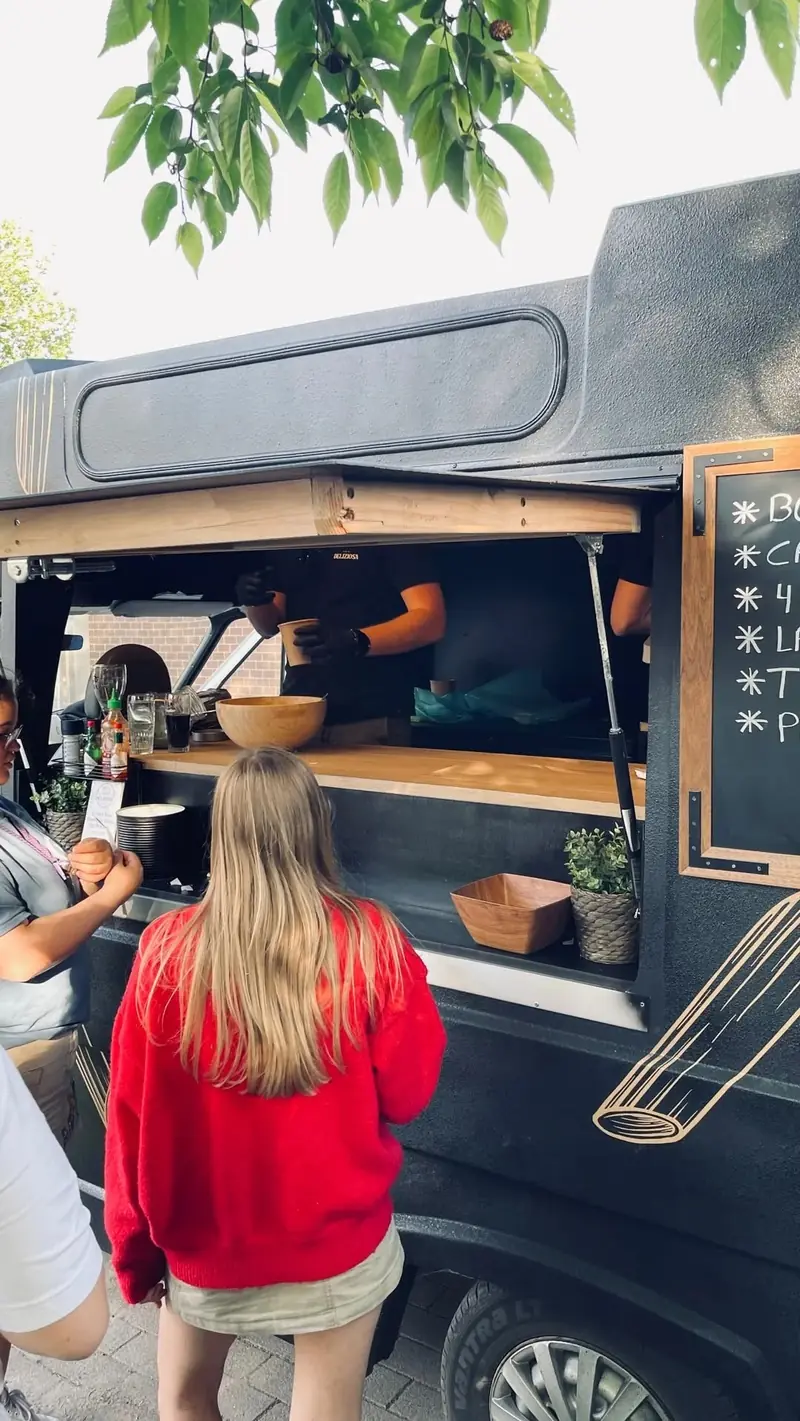 Gasten bestellen pasta aan het venster van de oldtimer