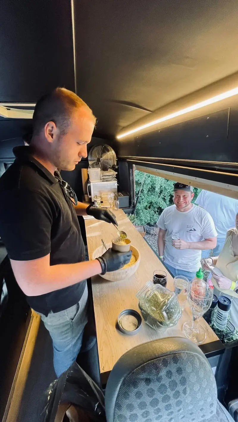 Kok bereidt pasta in de oldtimer terwijl gasten meekijken