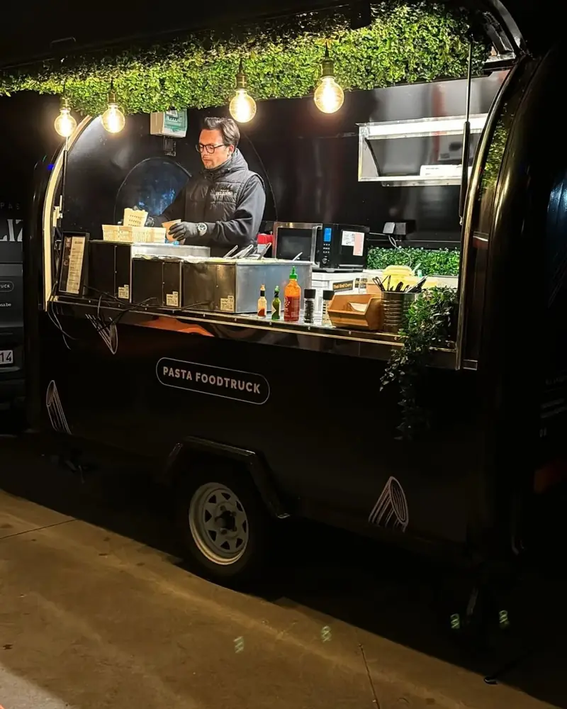 De foodtrailer 's avonds, met brandende lampjes en een groen plafond