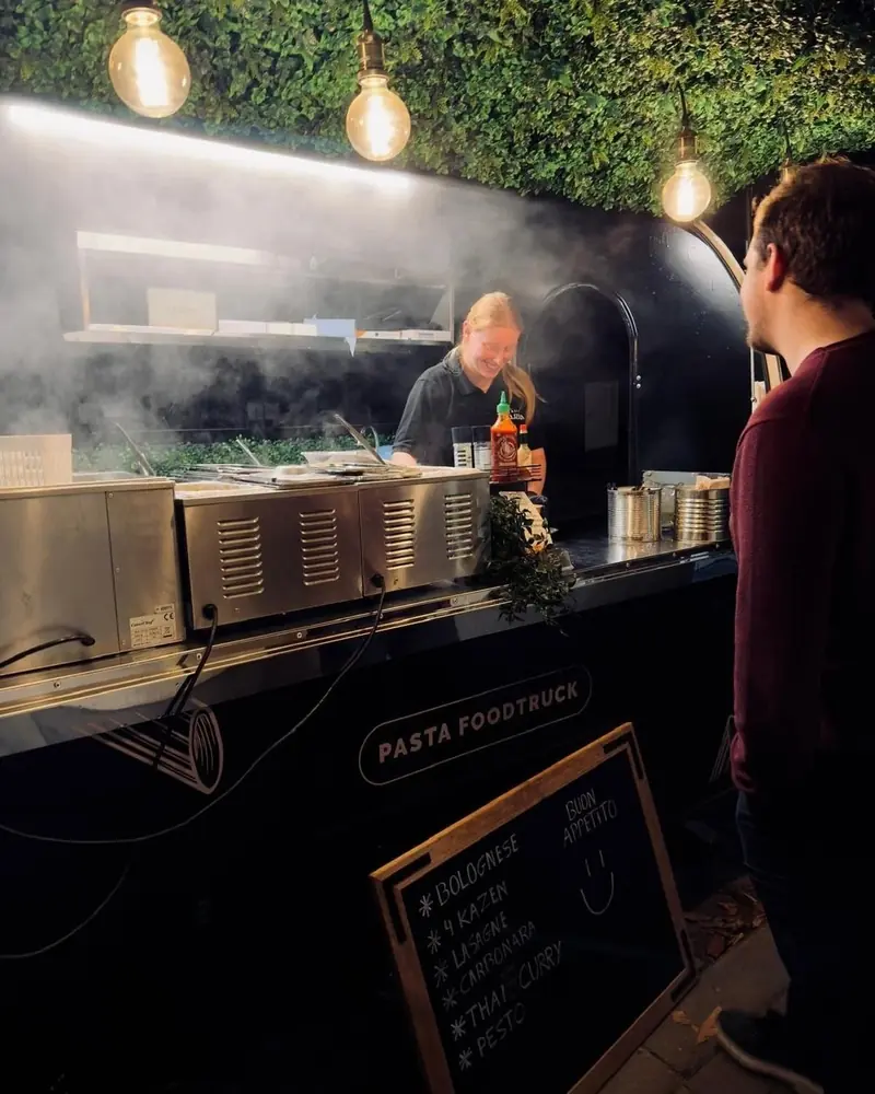 Kok in de foodtrailer, met stoom boven de pastapotten